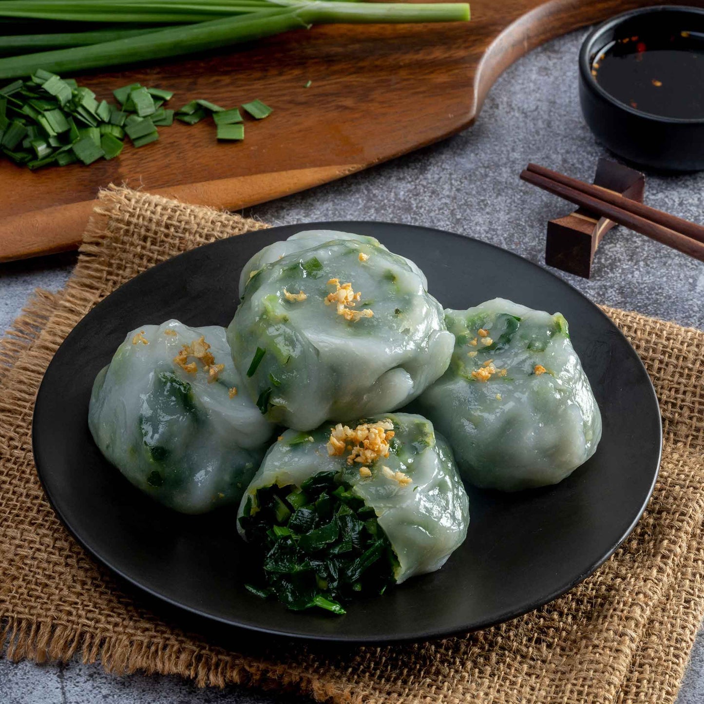 A close-up of dumplings on a plate, containing cooked garlic chives.