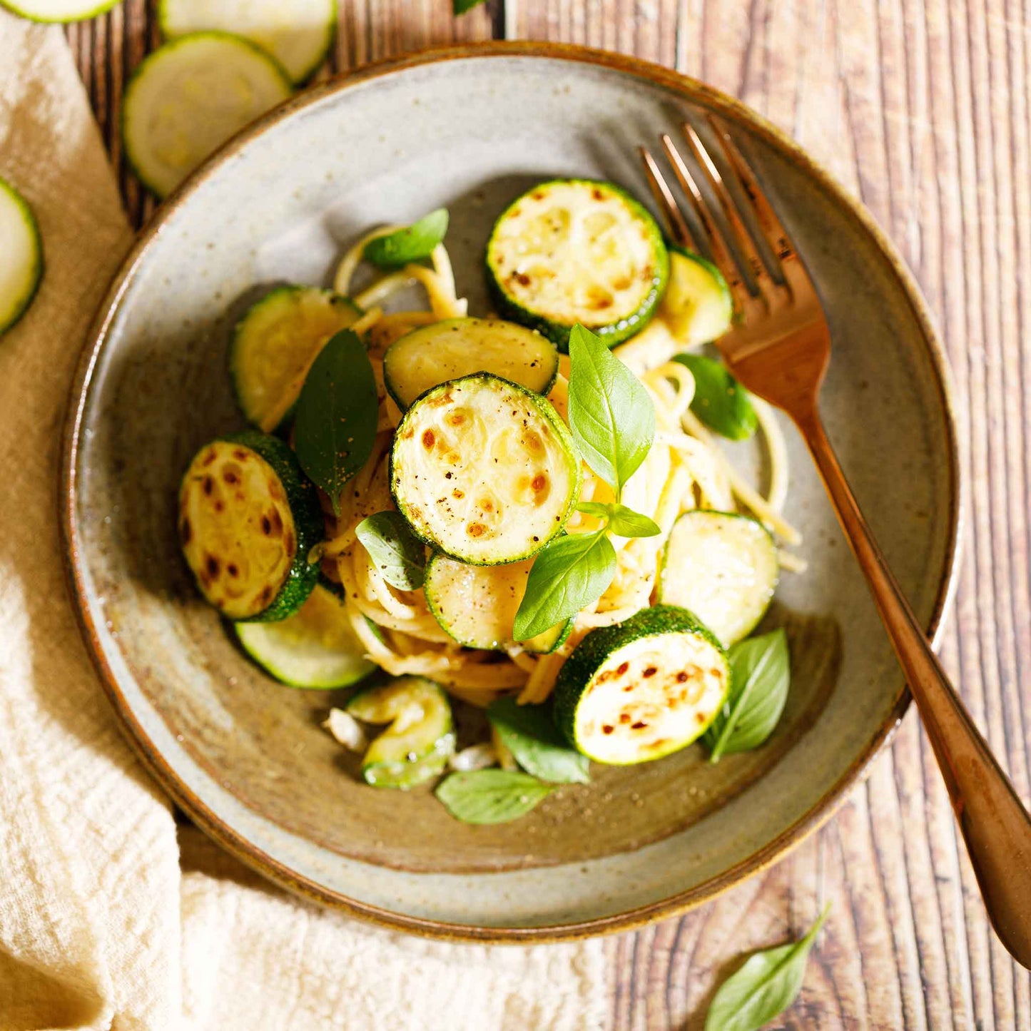 A bowl of cooked Black Beauty squash with some greens.