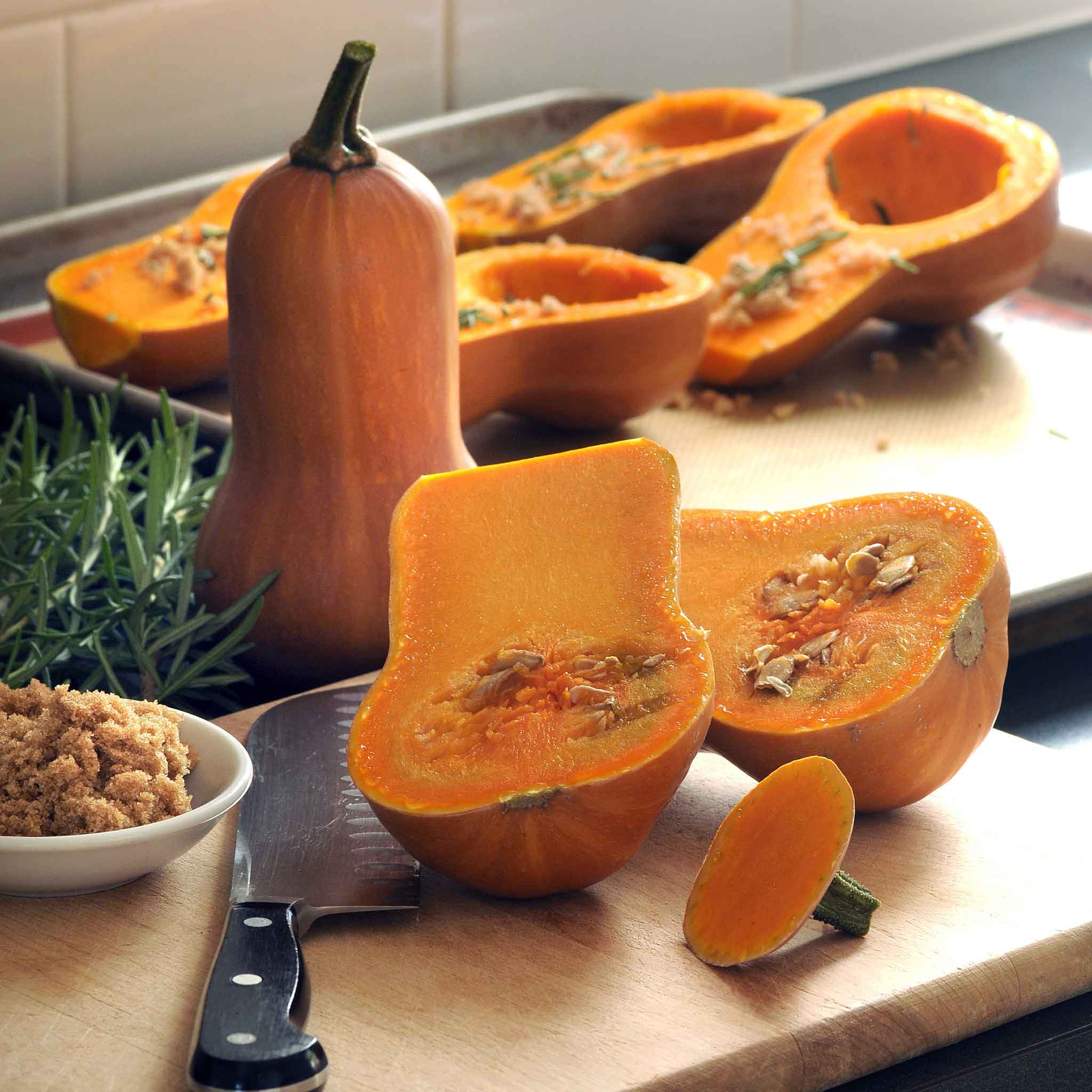 Butterbaby squash sliced open showing its orange flesh and seeds.