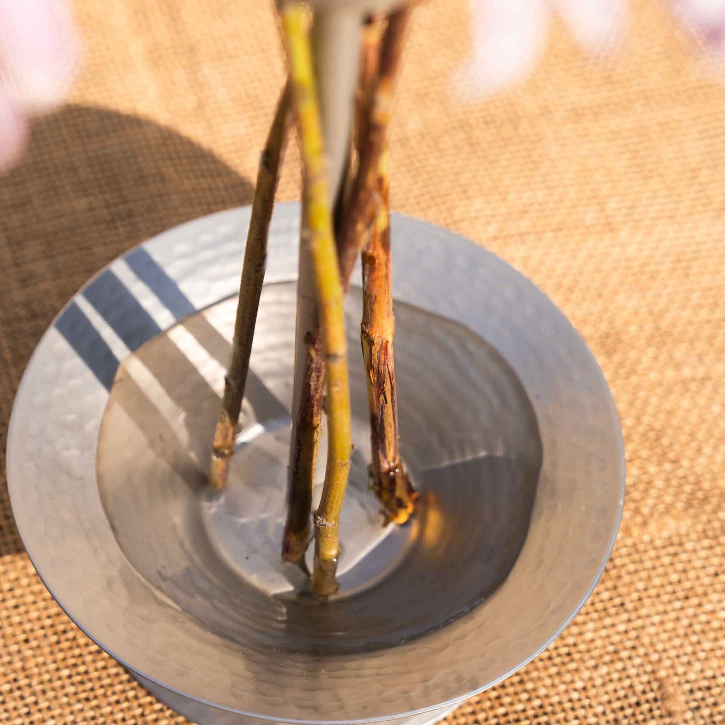 Up close and top view of the collective hammered metal stem vase with a burlap background