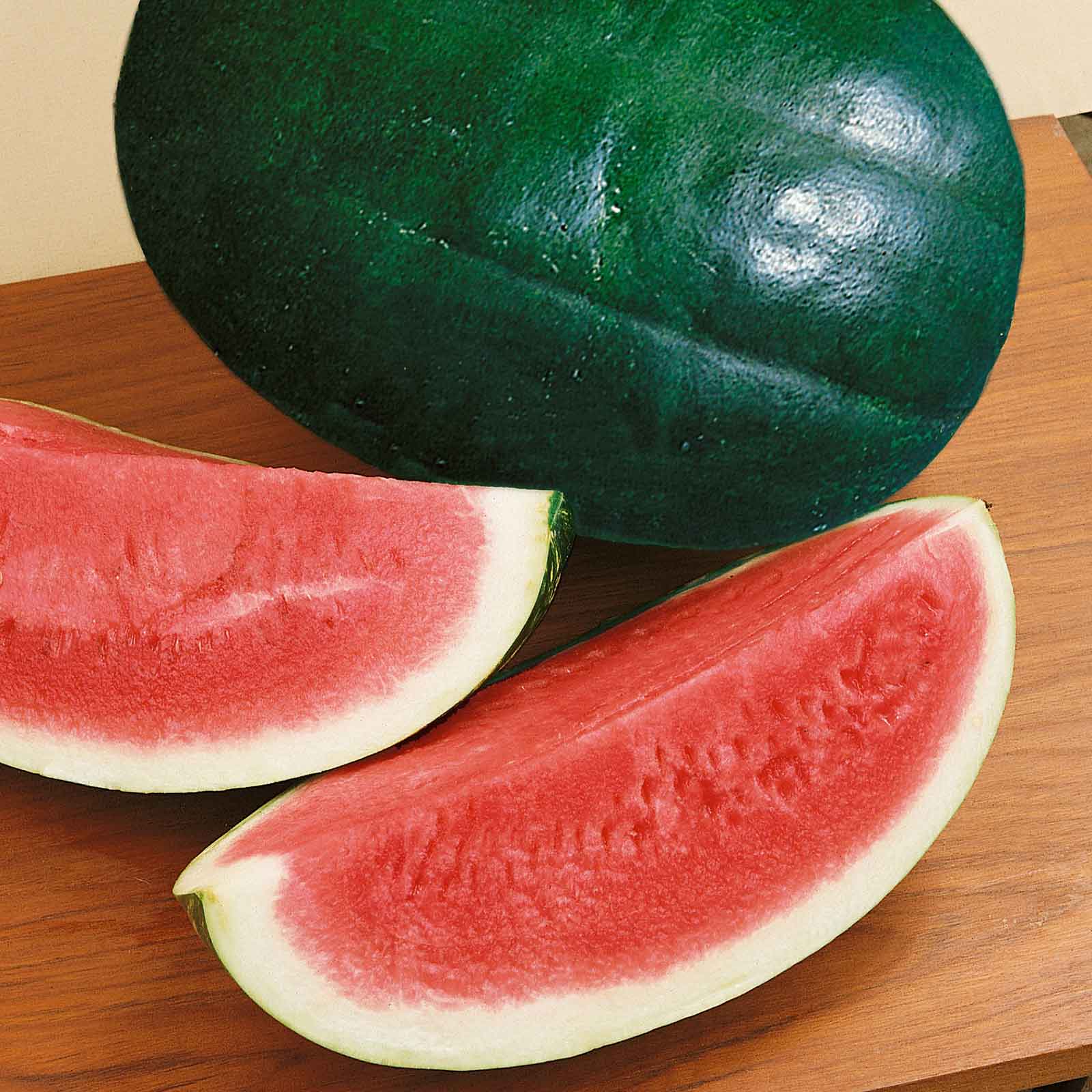 A Triple Baby watermelon with a dark green rind, shown with a slice of watermelon.