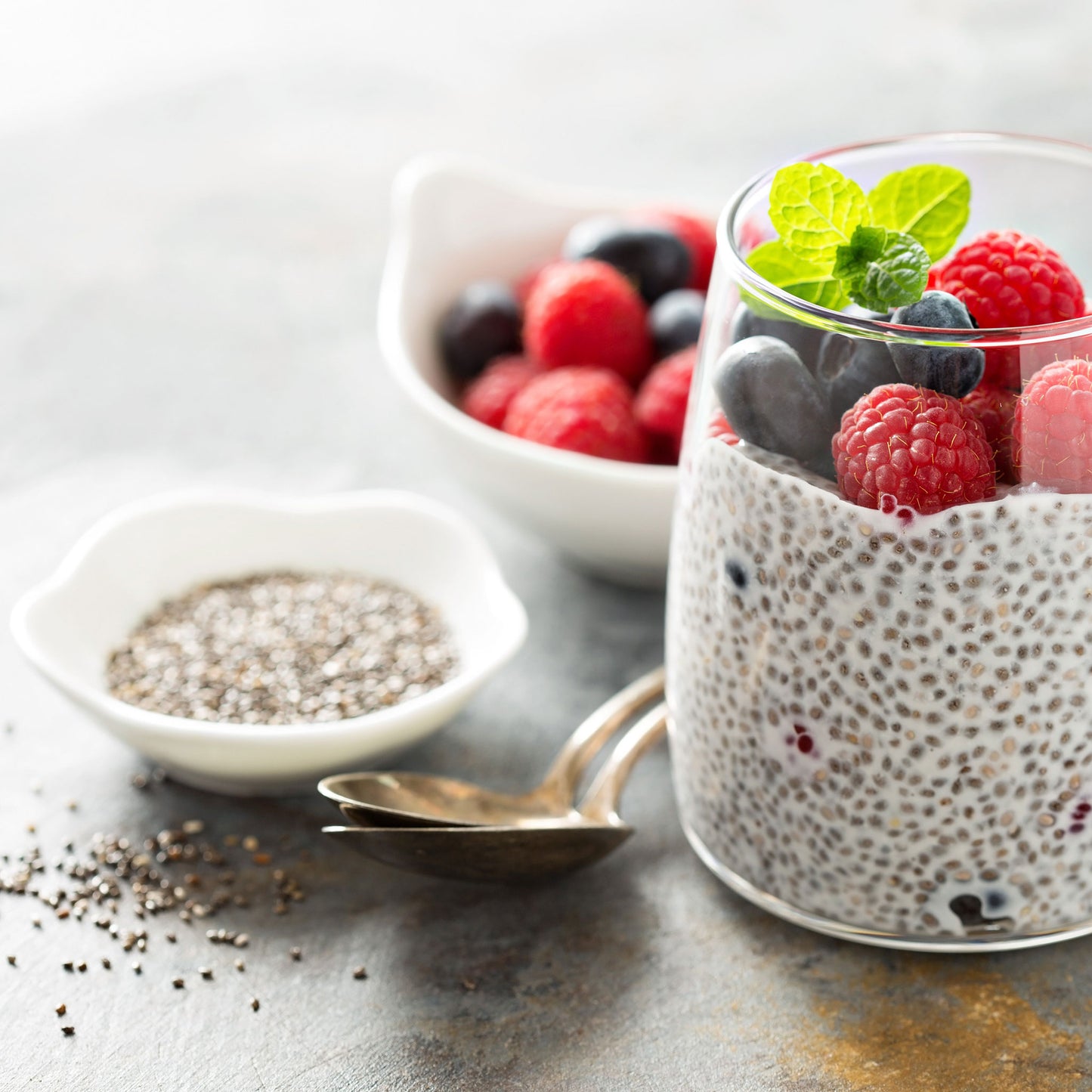 A close-up shot of chia seeds, highlighting their texture and small size next to fruit.