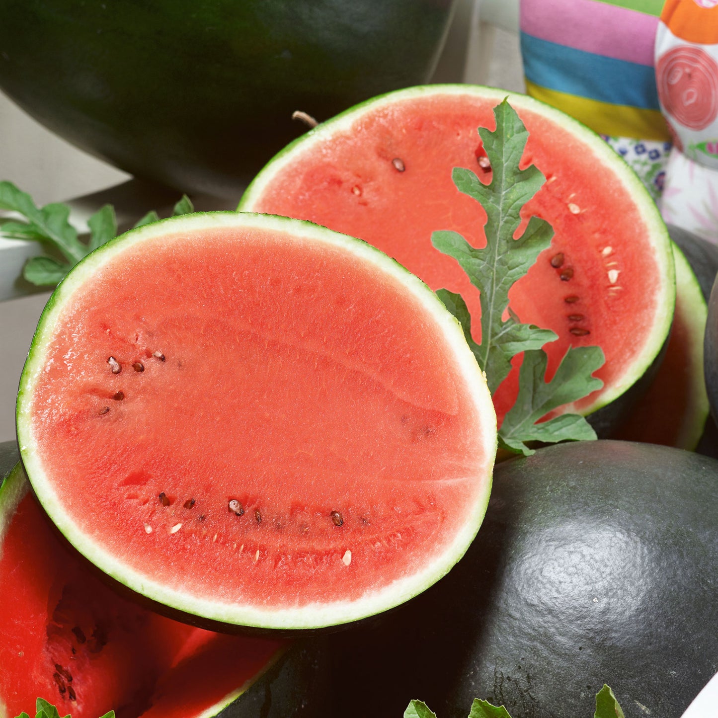 A ripe, round Sugar Baby Bush watermelon with dark green rind and faint stripes sits on a wooden surface.