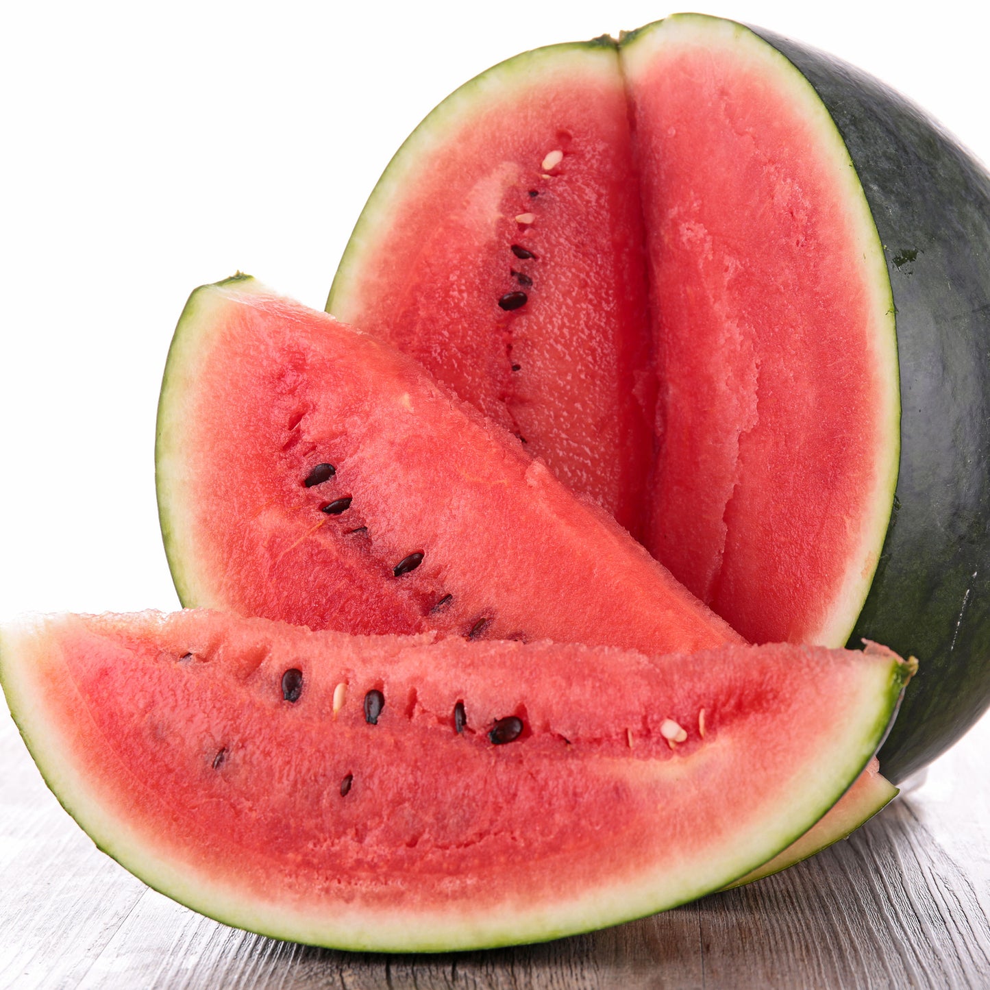 A dark green Sugar Baby watermelon sits on a wooden surface with a white background.