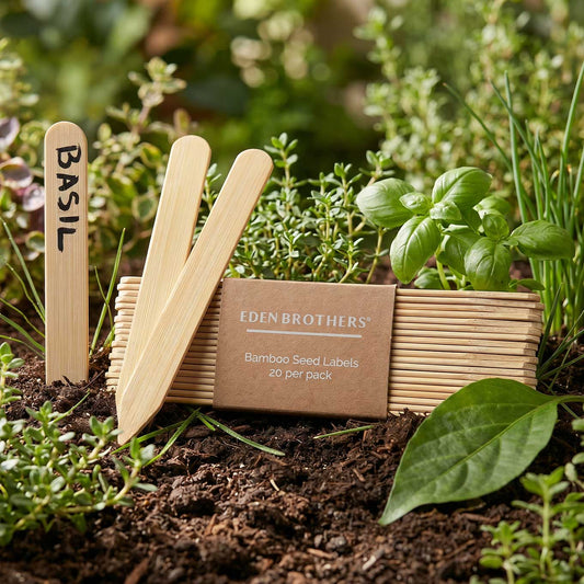 Bamboo seed labels for basil with a box of Eden Brothers bamboo seed labels in a garden setting.