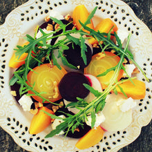 A plate of salad containing golden detroit beets sliced showing the golden interior and ready to eat. 