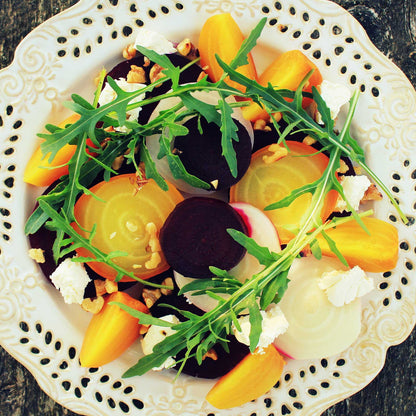 A plate of salad containing golden detroit beets sliced showing the golden interior and ready to eat. 