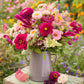 Bouquet of colorful flowers from the raspberry spritz bouquet in a metal vase with a garden background