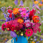 Colorful bouquet of flowers of the summer sangria bouquet in a blue vase with a blurred natural background