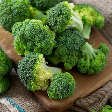 Broccoli appalachian green florets displayed on a wooden board and burlap.