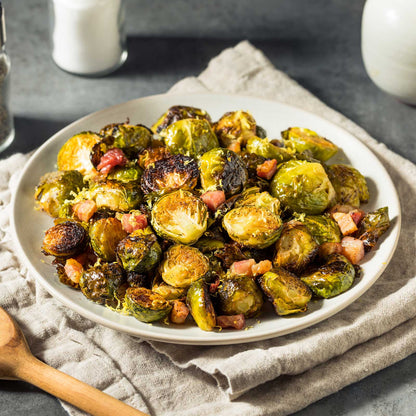 A plate of roasted silvia f1 brussels sprouts with other vegetales on a linen cloth.
