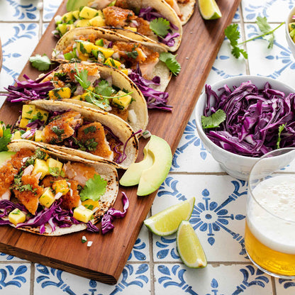 Several tacos garnished with Red Express cabbage on a tiled surface.