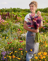 Woman holding a bouquet of flowers in a field of flowers
