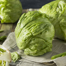 A close-up shot of a vibrant, crisp iceberg lettuce head, showcasing its tightly packed, pale green leaves.