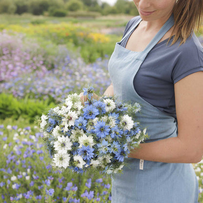 A person holding a bouquet of love in the mist mixed flowers in a natural setting