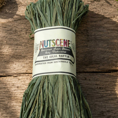 A bundle of the field green nutscene madagascan raffia with nutscene label on a wooden background