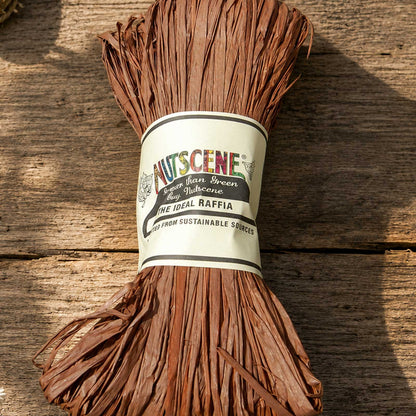 A bundle of the mocha mousse nutscene madagascan raffia with nutscene label on a wooden background