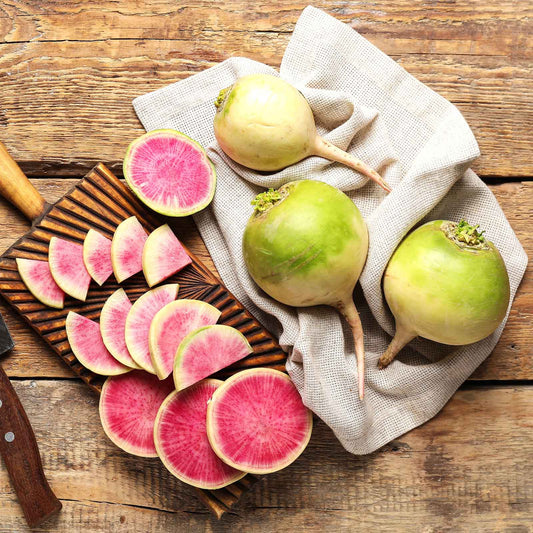 A cross-section of a watermelon radish, showcasing its vibrant pink interior and white exterior.