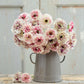 A bouquet of the ranunculus brushmark cesar and galthie bundle on a wooden table