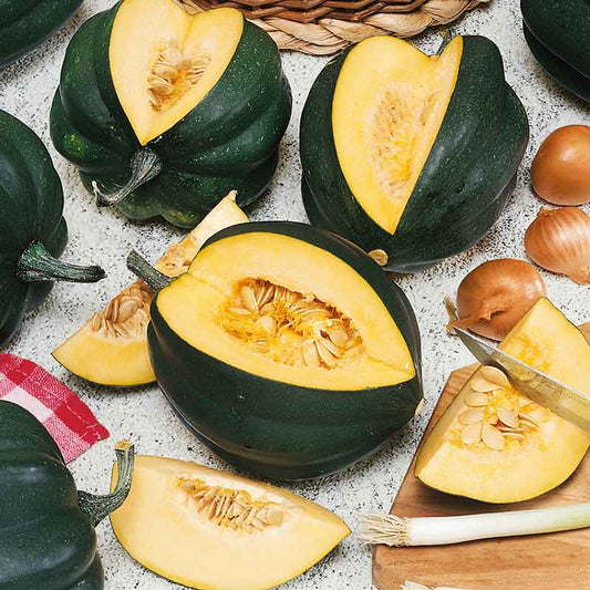 Table King Bush squash with section cut out showing inside flesh and seeds.
