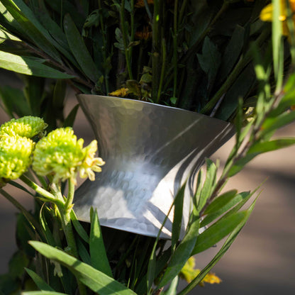 A close up of The collective floral bouquet ring showing its use and hammered metal finish