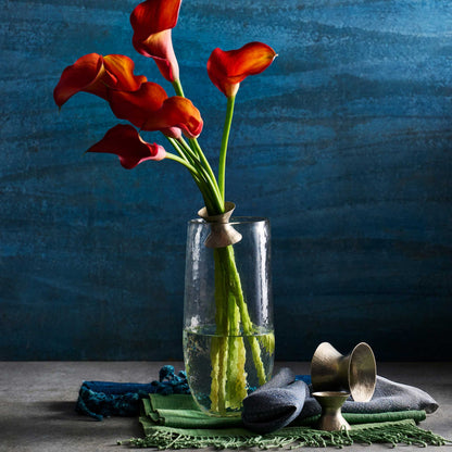 The collective floral bouquet ring shown holding the stems of five red flowers in a clear vase with water at the bottom.