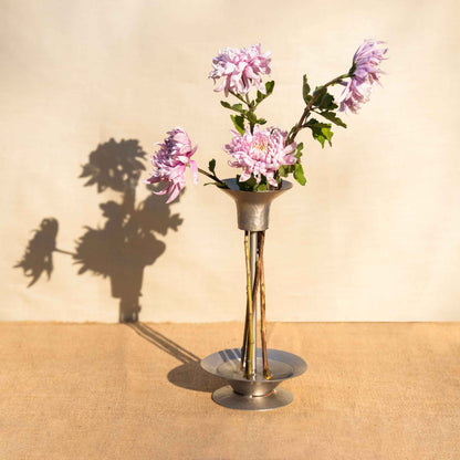 An arrangement using the collective hammered metal stem vase and bouquet ringson a wooden table and neutral background