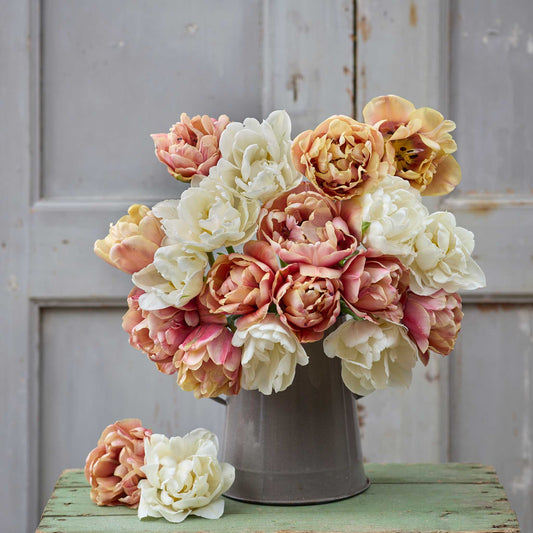 A person holding a pink and yellow bouquet from the la belle epoque and mount tacoma tulip bundle