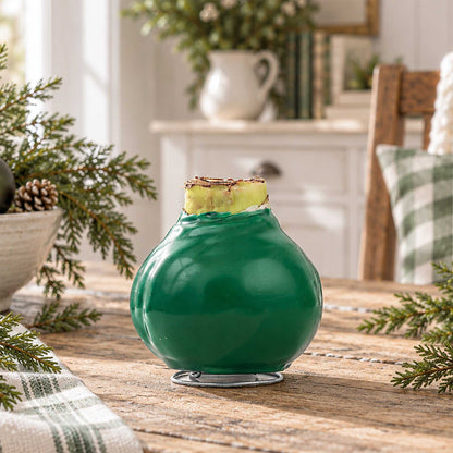 Green wax amaryllis bulb with white blooms in an indoor setting showing only the bulb