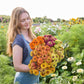 A person holding a bouquet of the zinnia bundle queeny series in a garden setting